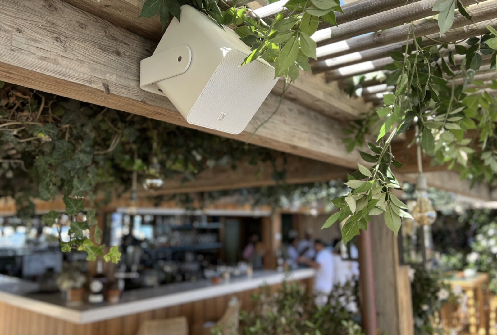 Enceinte exterieure installee sous une pergola de terrasse
